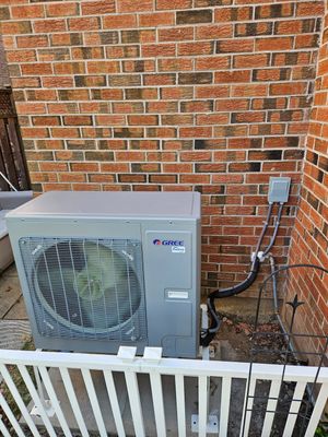 Gree inverter air conditioning unit installed against a brick wall